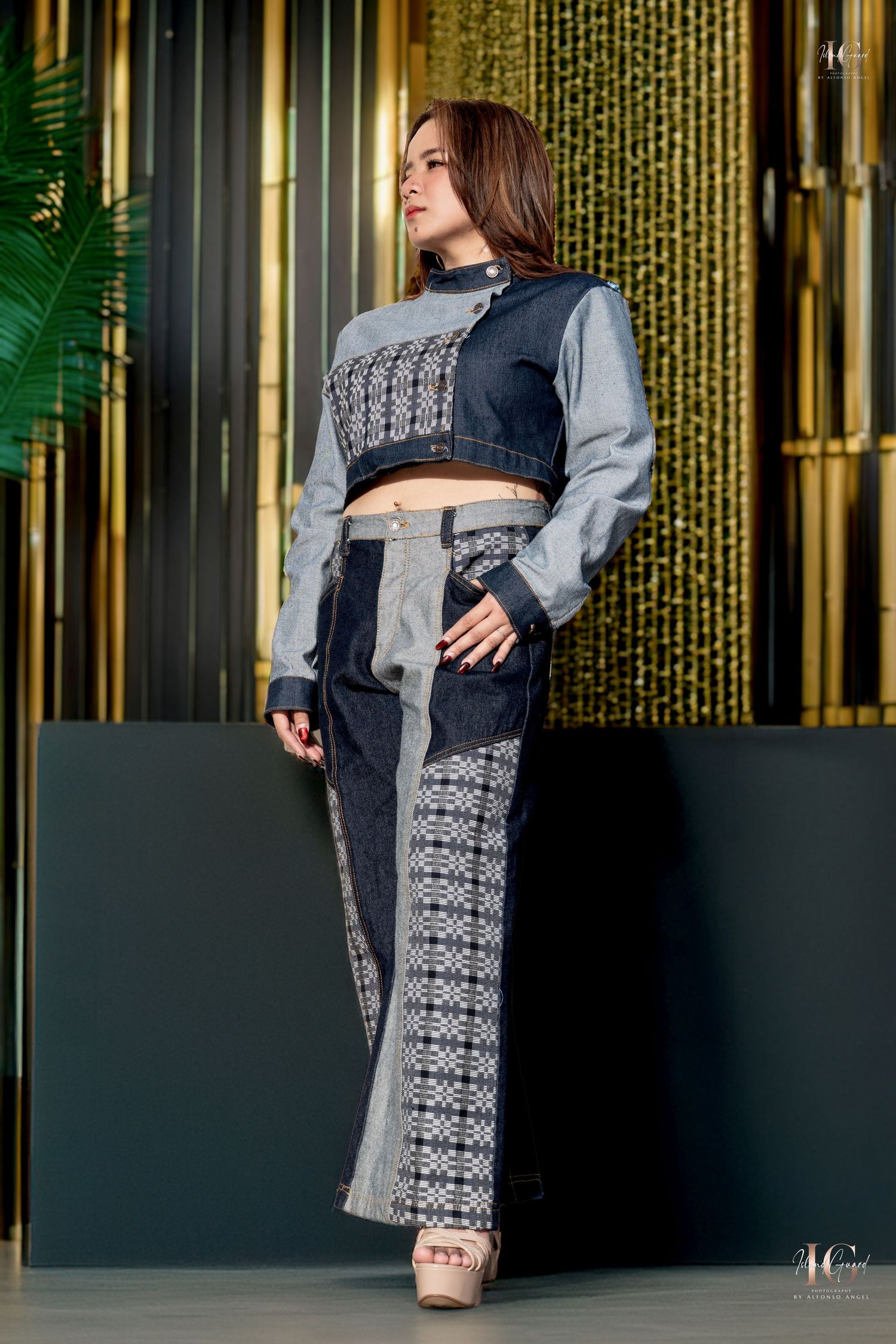 A fashion model poses in a gray and black coordinated crop top and wide-leg pants set with decorative pattern details.