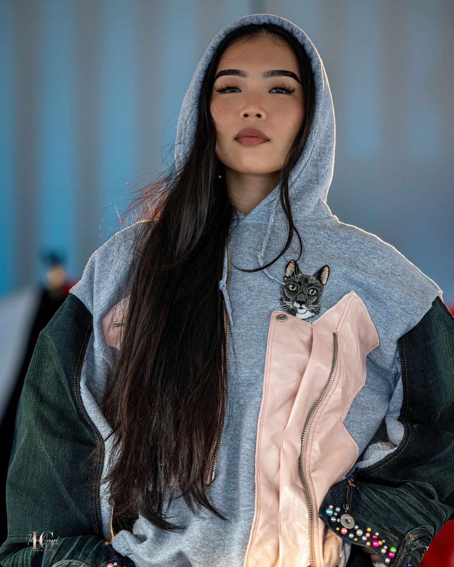 Streetwear fashion look with color block hoodie and dark long hair on runway.