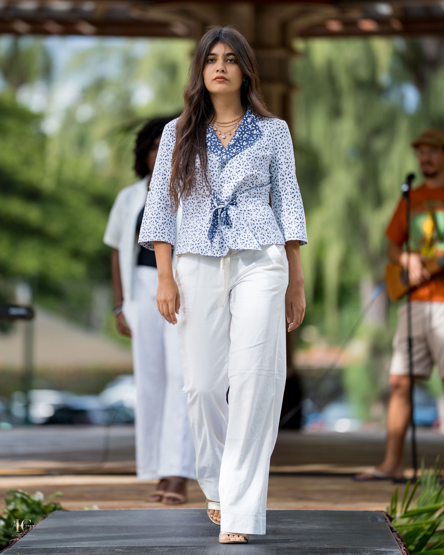 A series of fashion photos showing white linen pants and a blue patterned top styled in an outdoor setting.