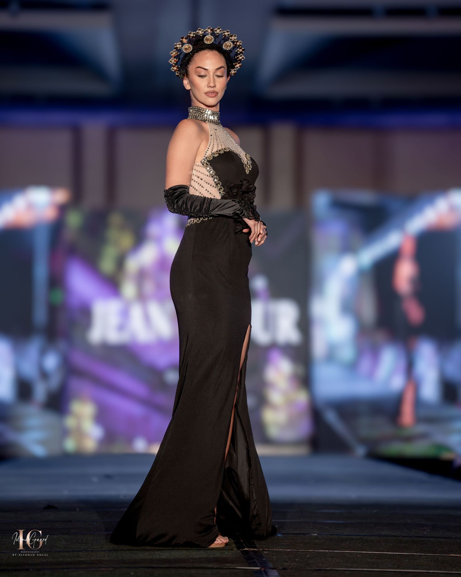Evening gown in black with sheer bodice and fitted silhouette presented at fashion show.