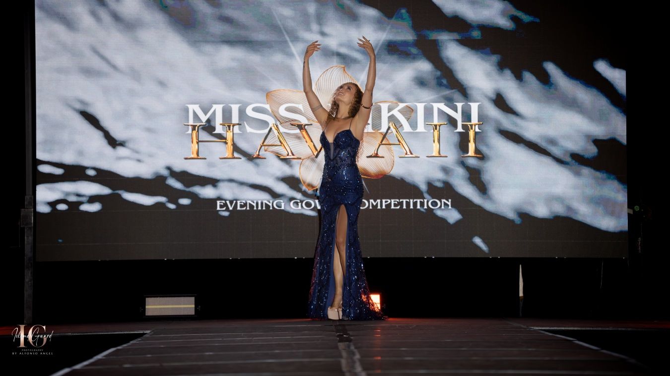 Models walk down a dark fashion runway with dramatic stormy cloud projections and lighting effects during a fashion show.