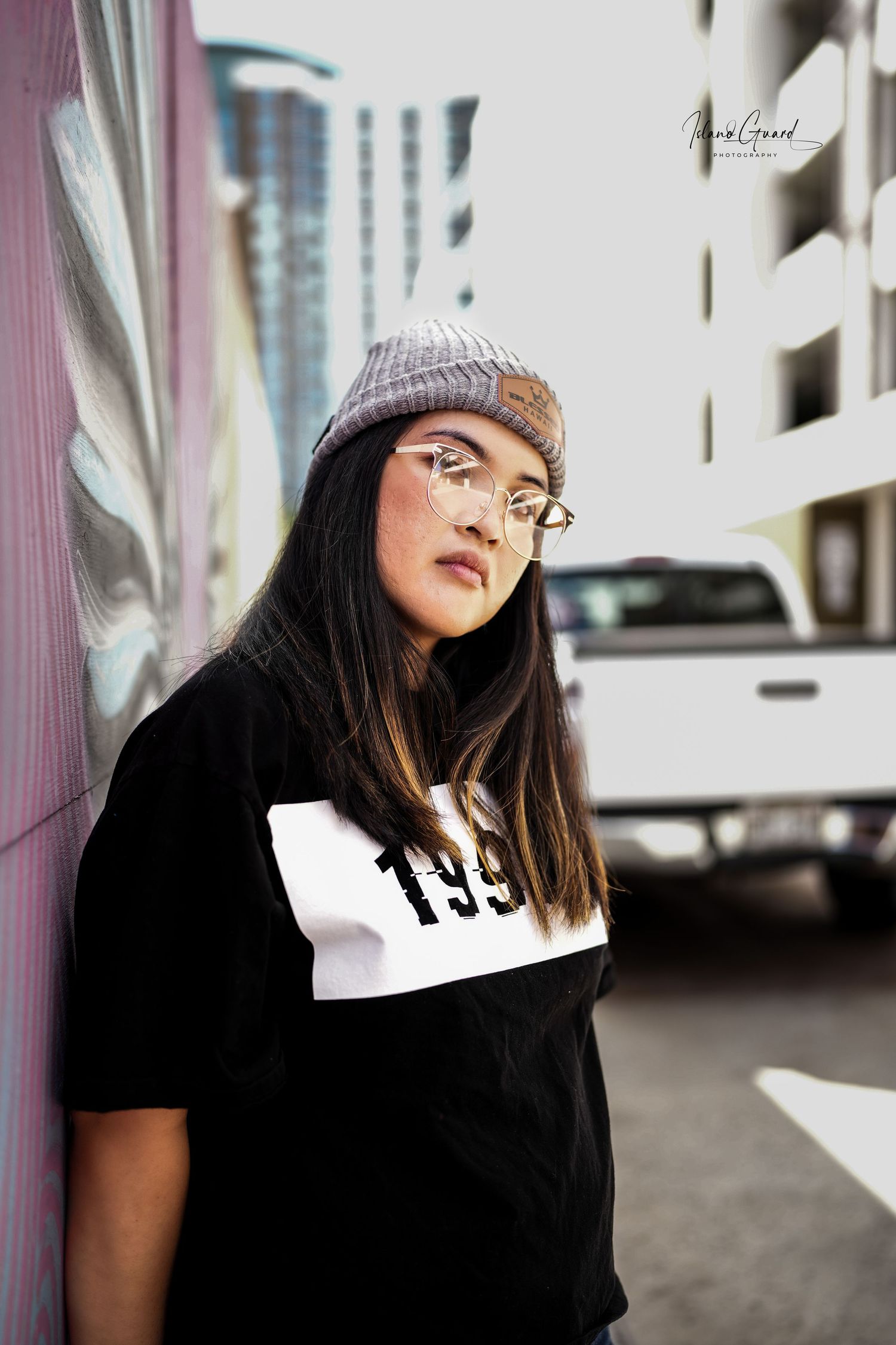 Portrait shots of person wearing beanie and glasses against urban background.