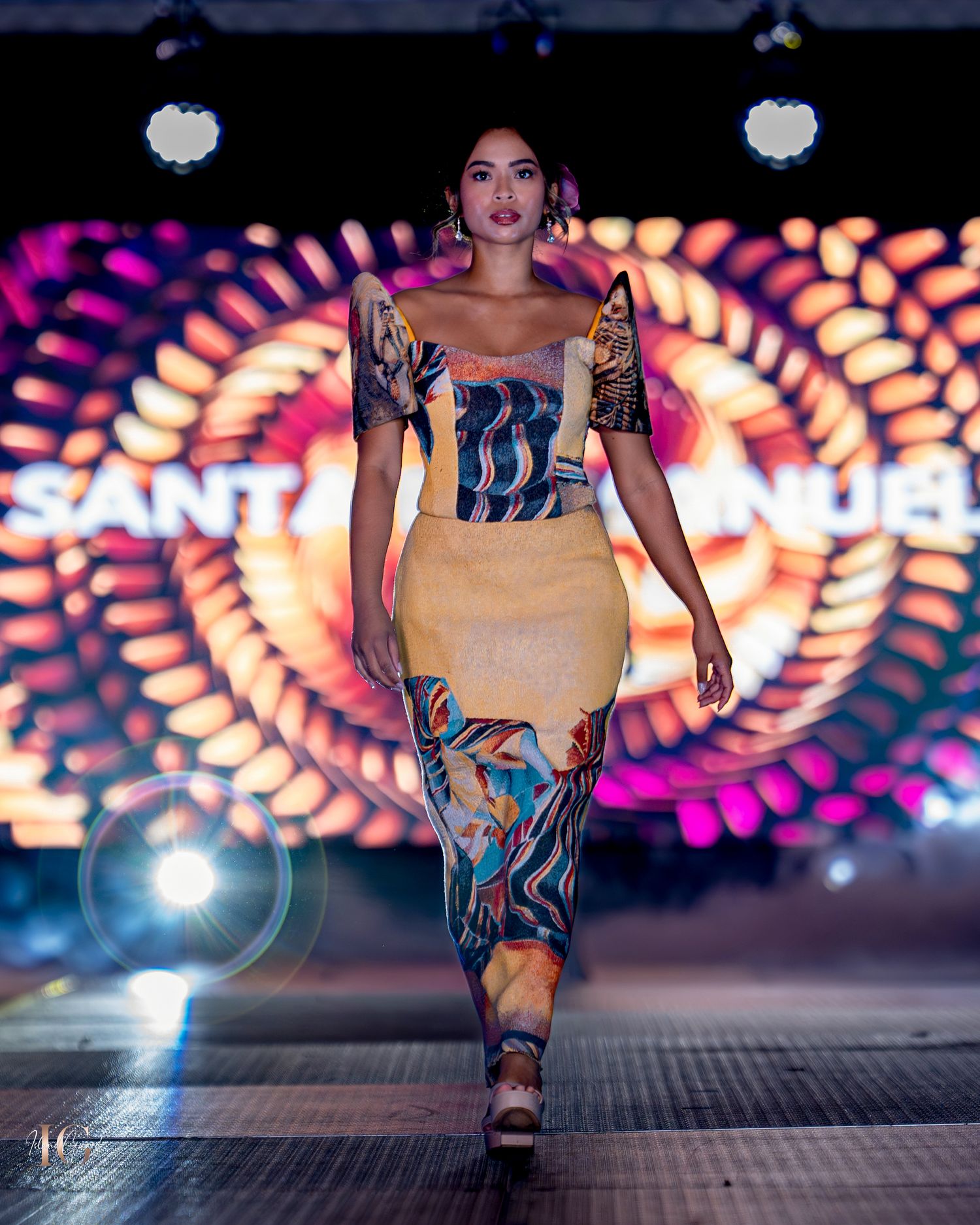 Stylish form-fitting dress with geometric patterns and bold designs showcased on fashion runway with vibrant lighting.