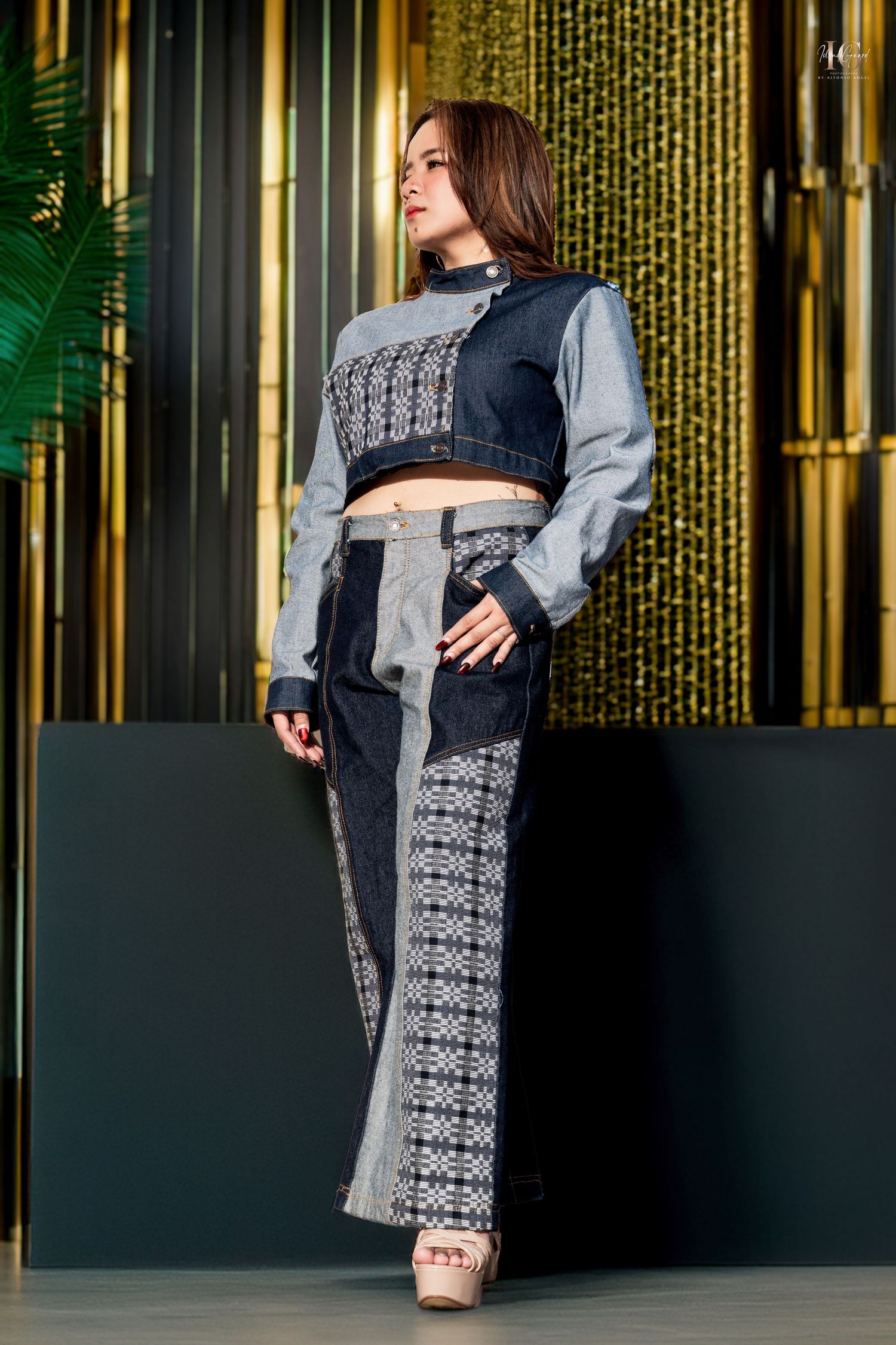 Fashion shoot featuring grey and black patterned coat against golden metallic backdrop.