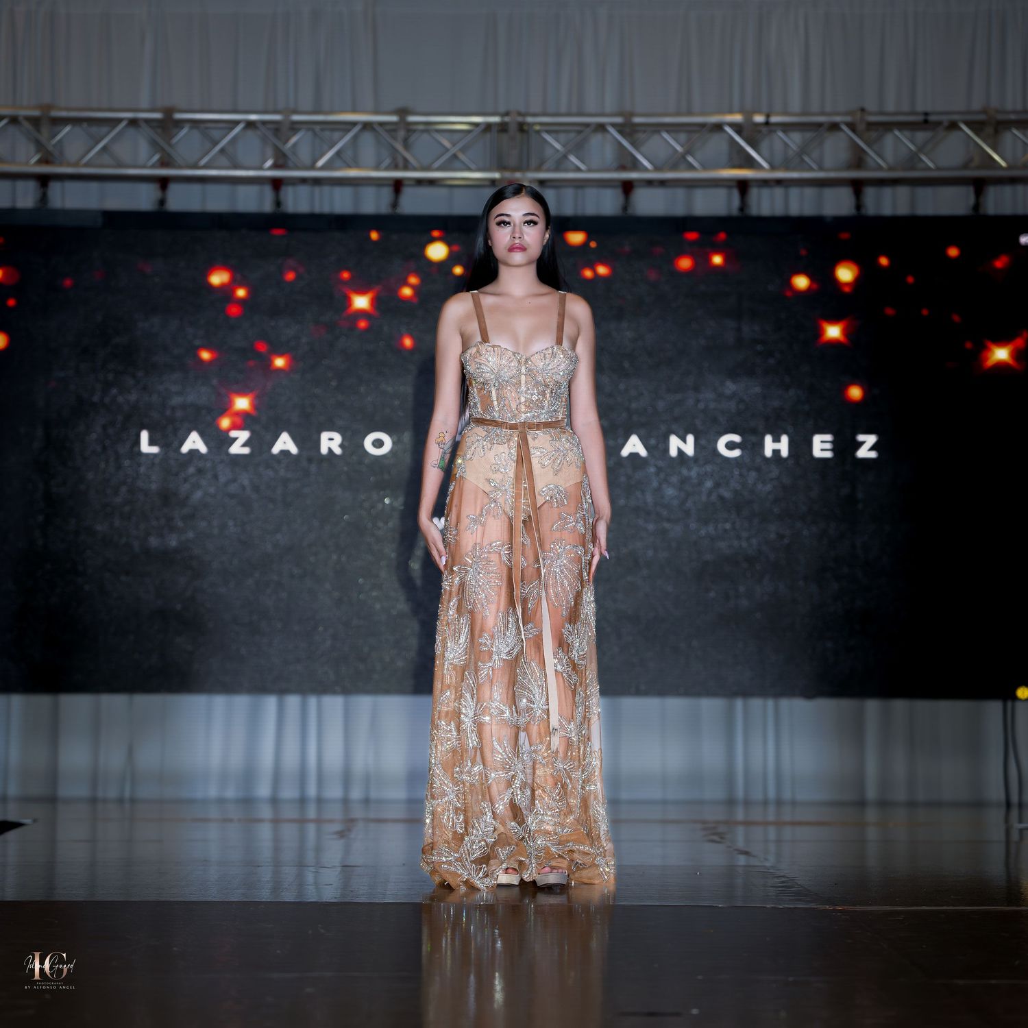 Champagne colored empire waist gown featured during designer runway presentation.