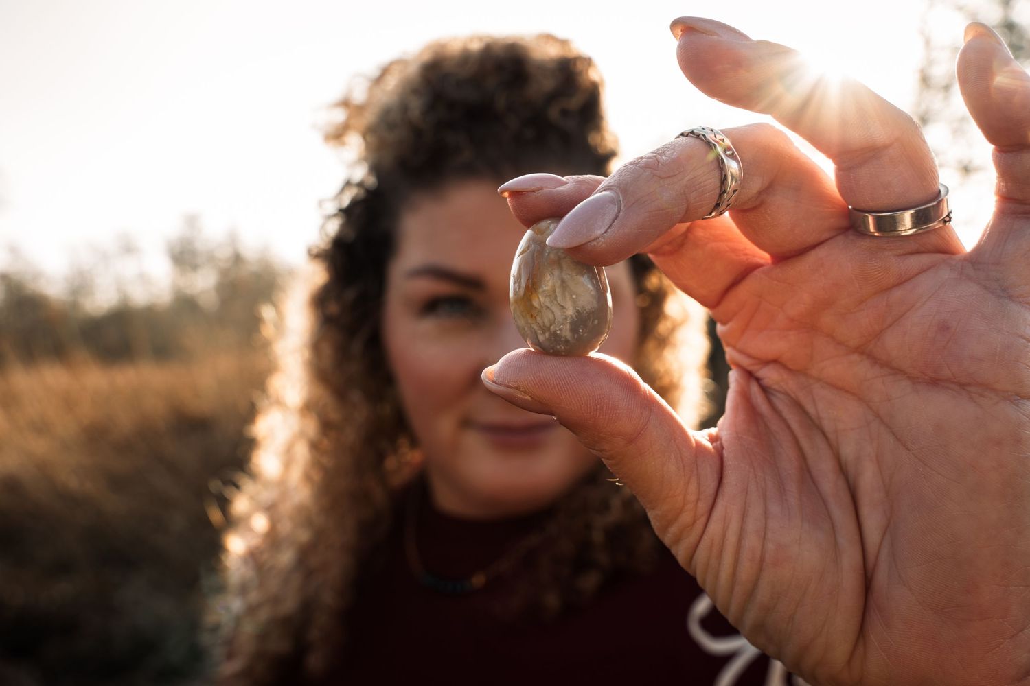 A series of hands holding and examining a small gold coin against different backgrounds and lighting conditions.