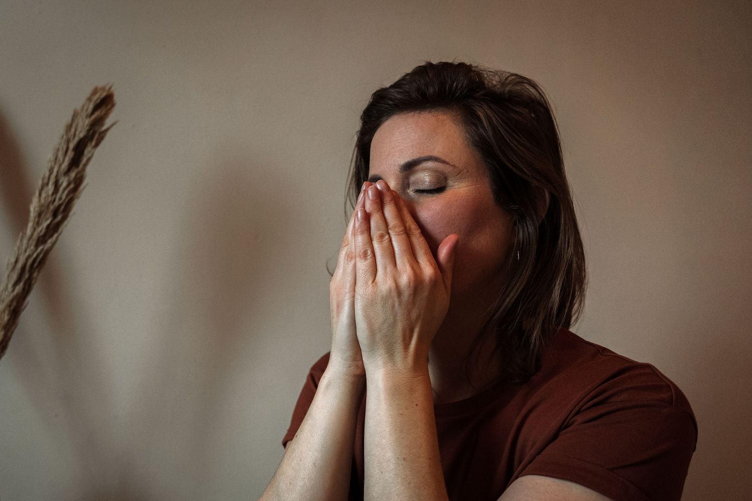 A person covers their face with their hands in a series of progressive images showing emotional distress.