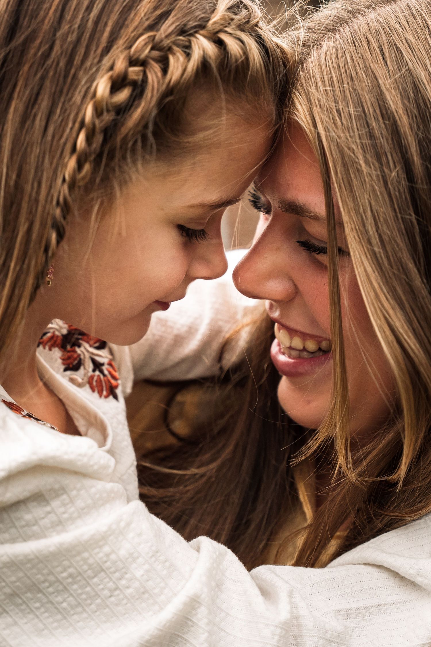 Two people in white sweaters share an intimate moment in a series of close-up photographs.
