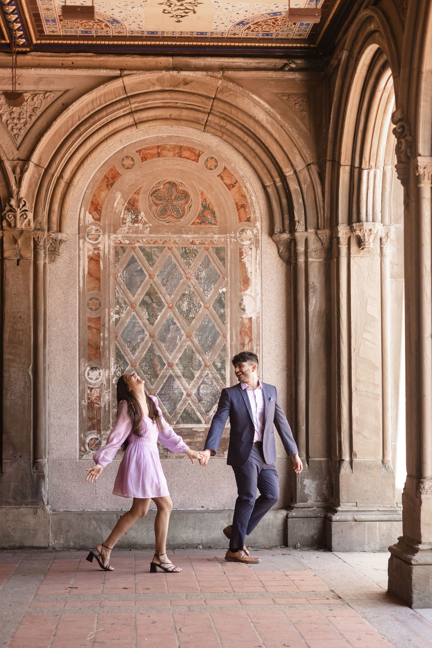 couple running under bethesda terrace with big laughter