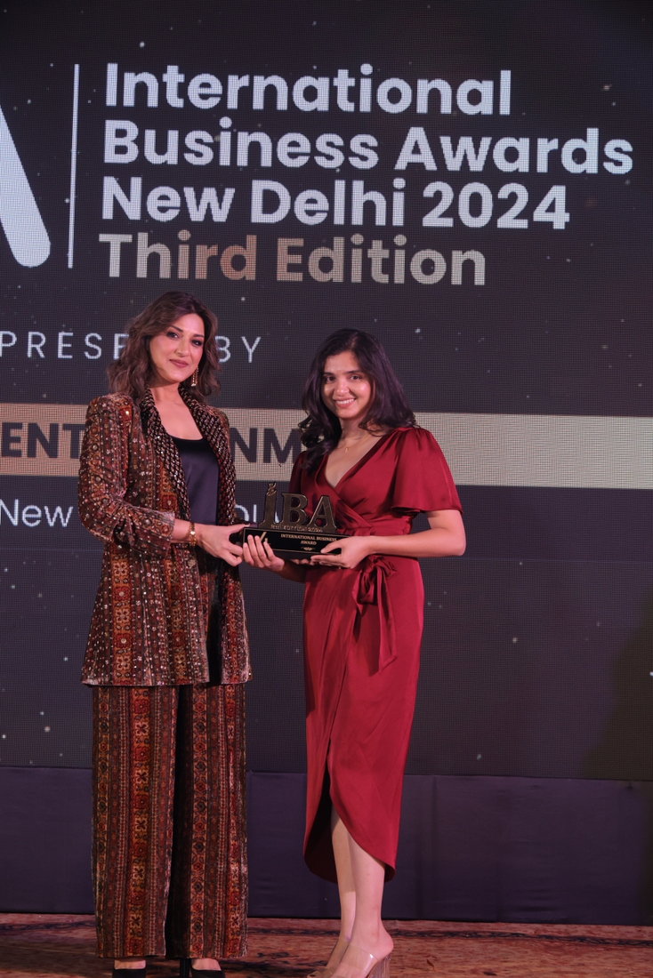Two people in formal attire presenting an award at the International Business Awards New Delhi 2024 ceremony.