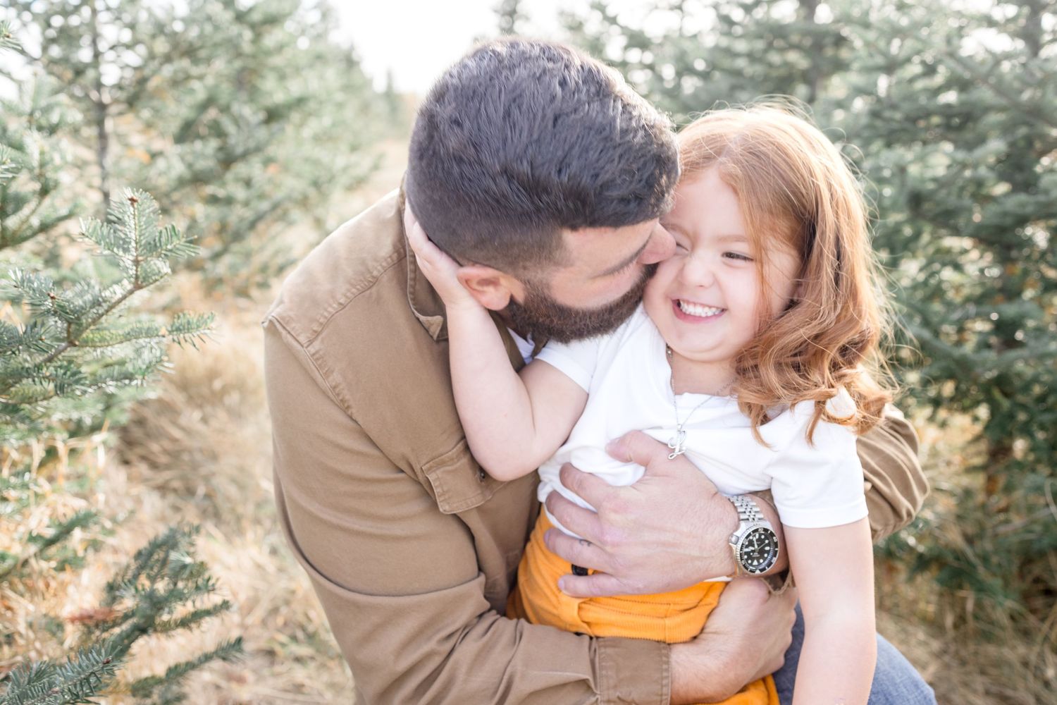 Playful family photo session outdoors with warm lighting and natural expressions.