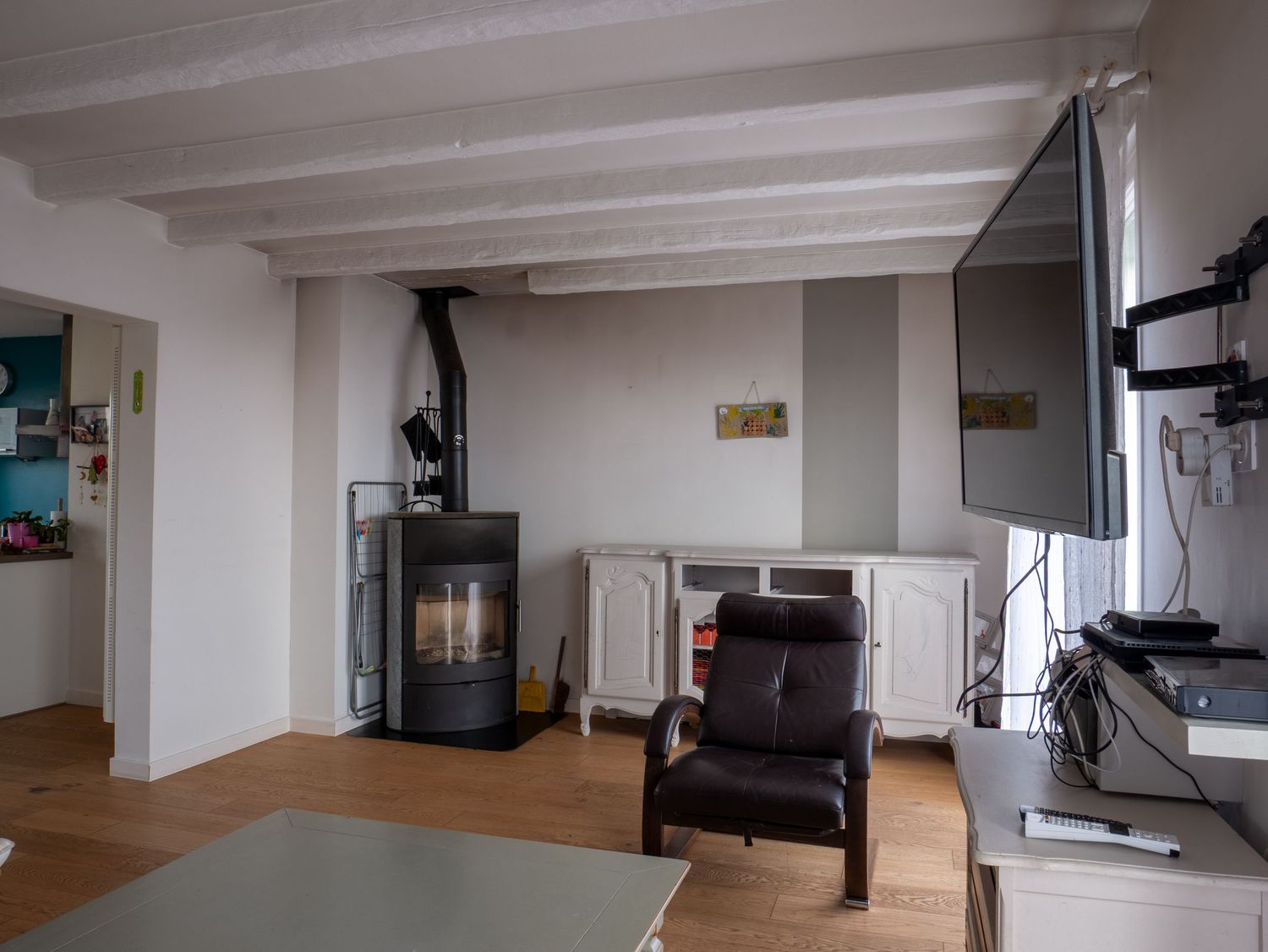 photo immobiliere d'un salon avec un poele et un fauteuil