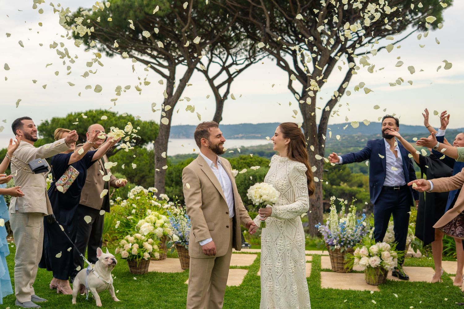 Photo d'un couple marié et des invités qui lance des petales de fleur