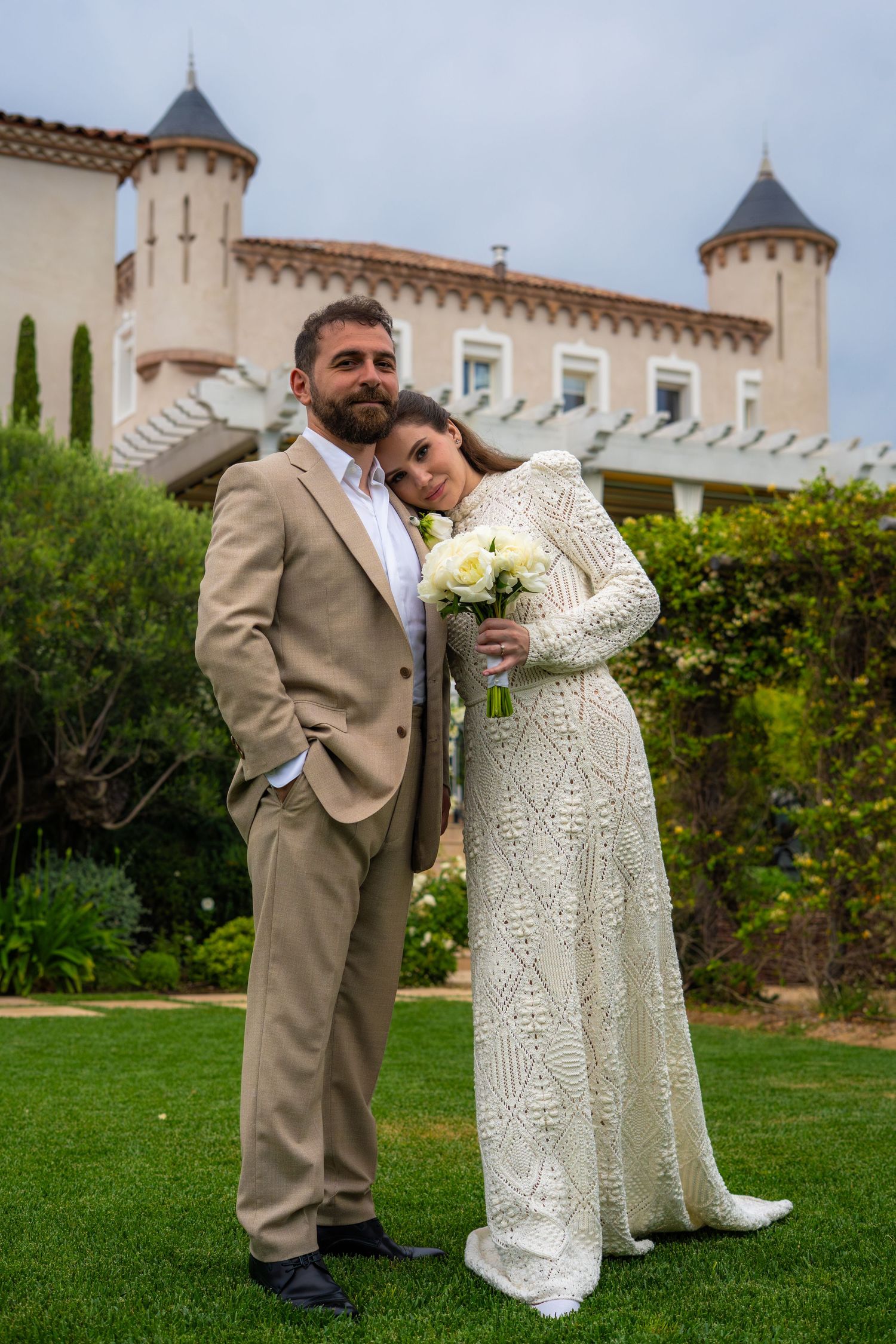 photo d'un couple, la femme a la tete sur l'epaule de l'homme avec un chateau en fond