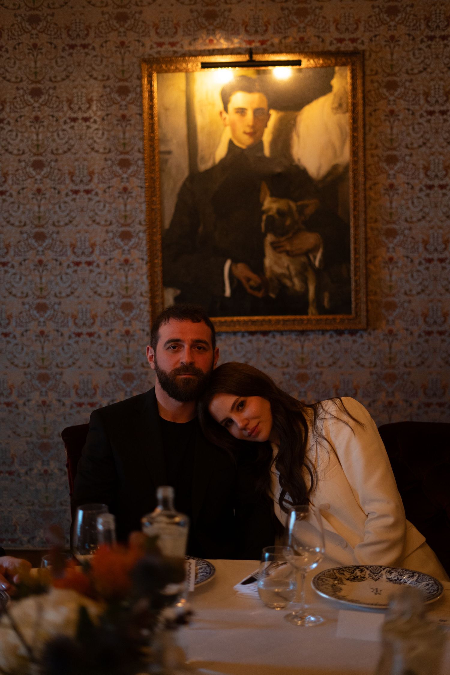Photo des mariés assis avec la mariée qui a sa tete sur l'épaule de son marie