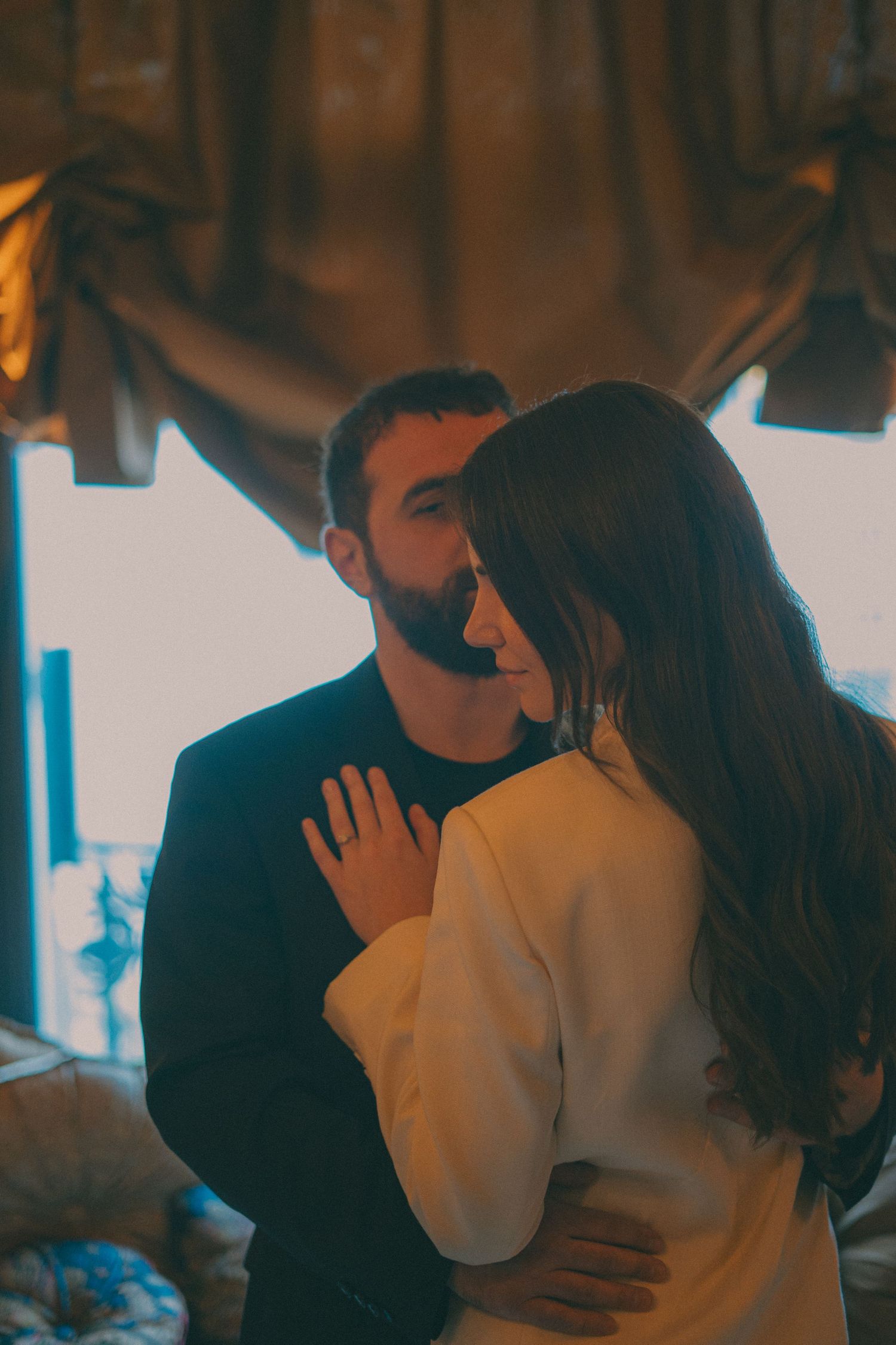 Photo d'un couple de jeune marié ou l'on apercois les visages et l'objectif est focus sur la bague