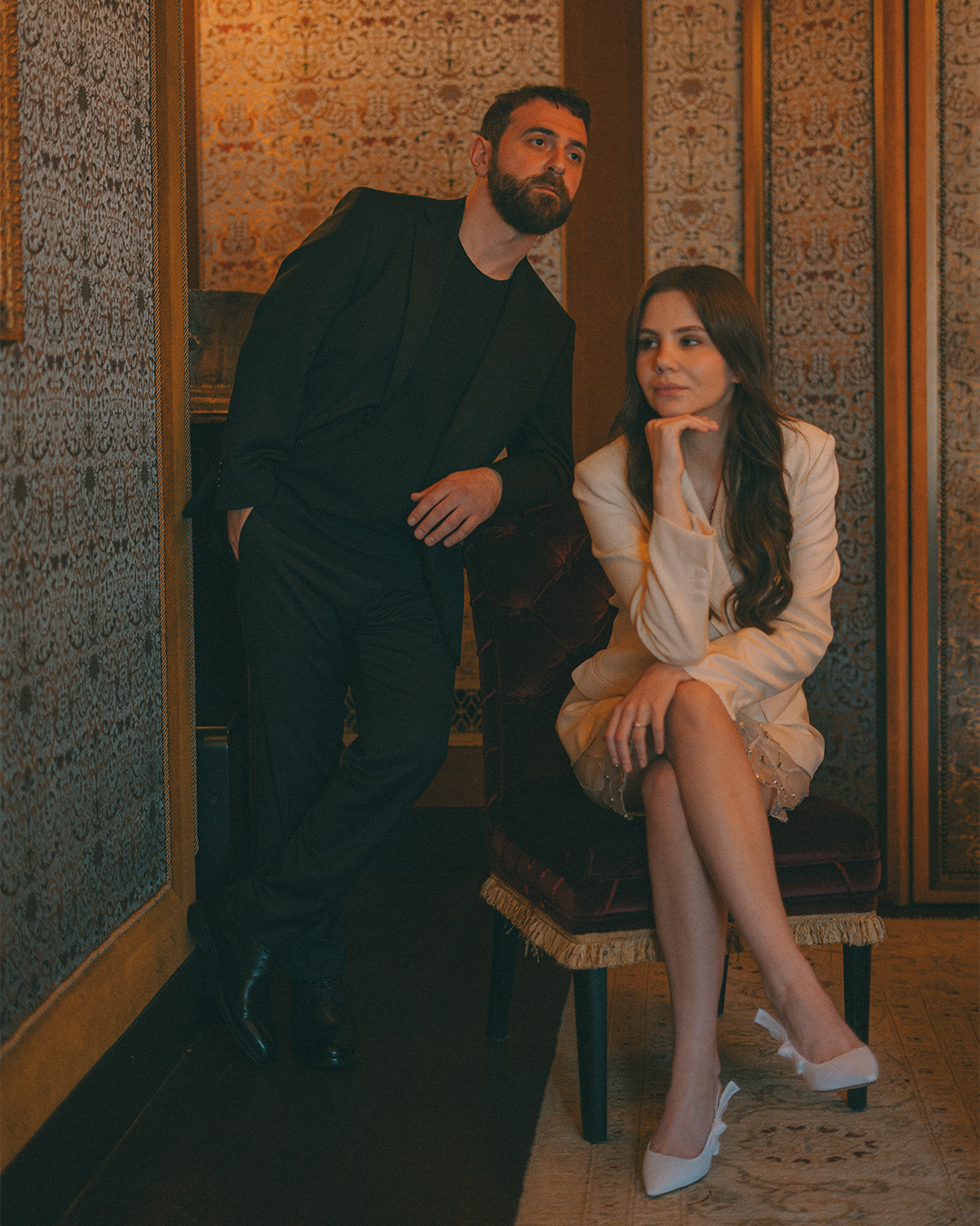 Photo d'un couple à la maison Revka de paris avec l'homme debout accouder à un fauteuil et la femme assise le regard dans le vide