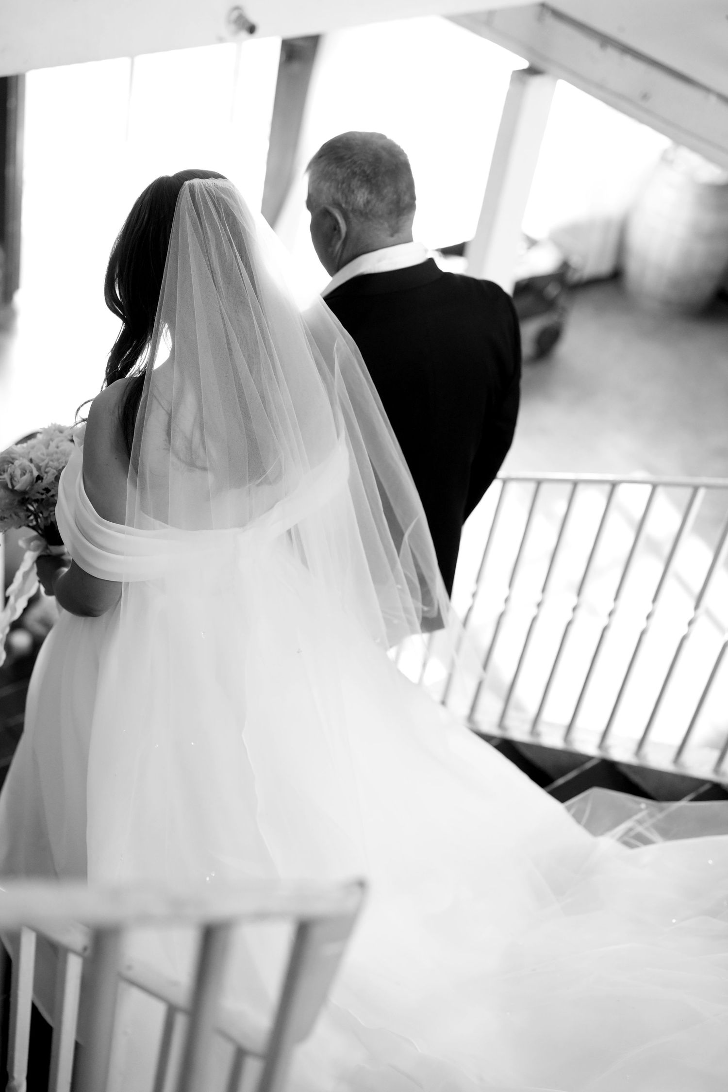 Ethereal black and white photos capture flowing wedding dress and veil in soft natural light.