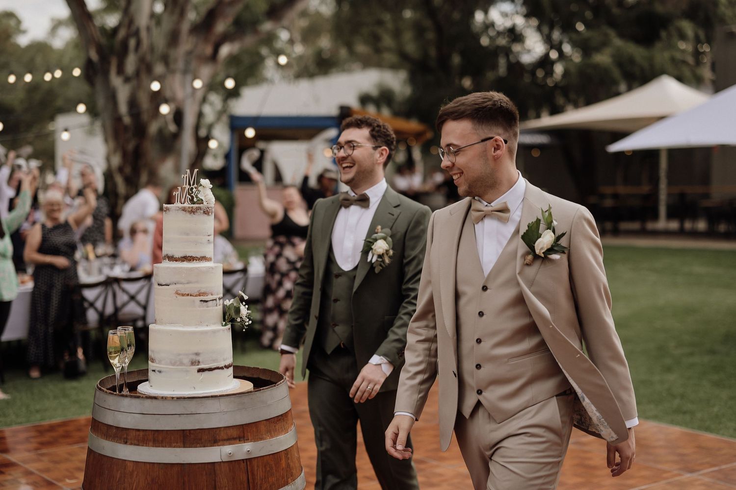 Wedding celebration at an outdoor venue with string lights and rustic barrel decor.
