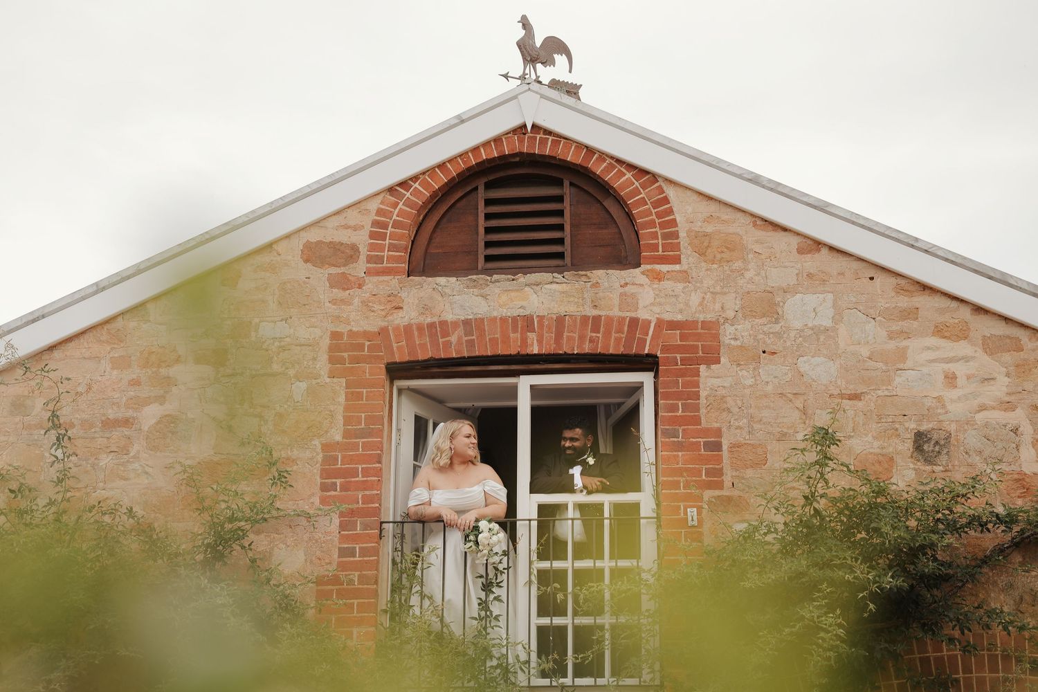 Historic stone building with arched brick windows and rustic architectural details in a countryside setting.