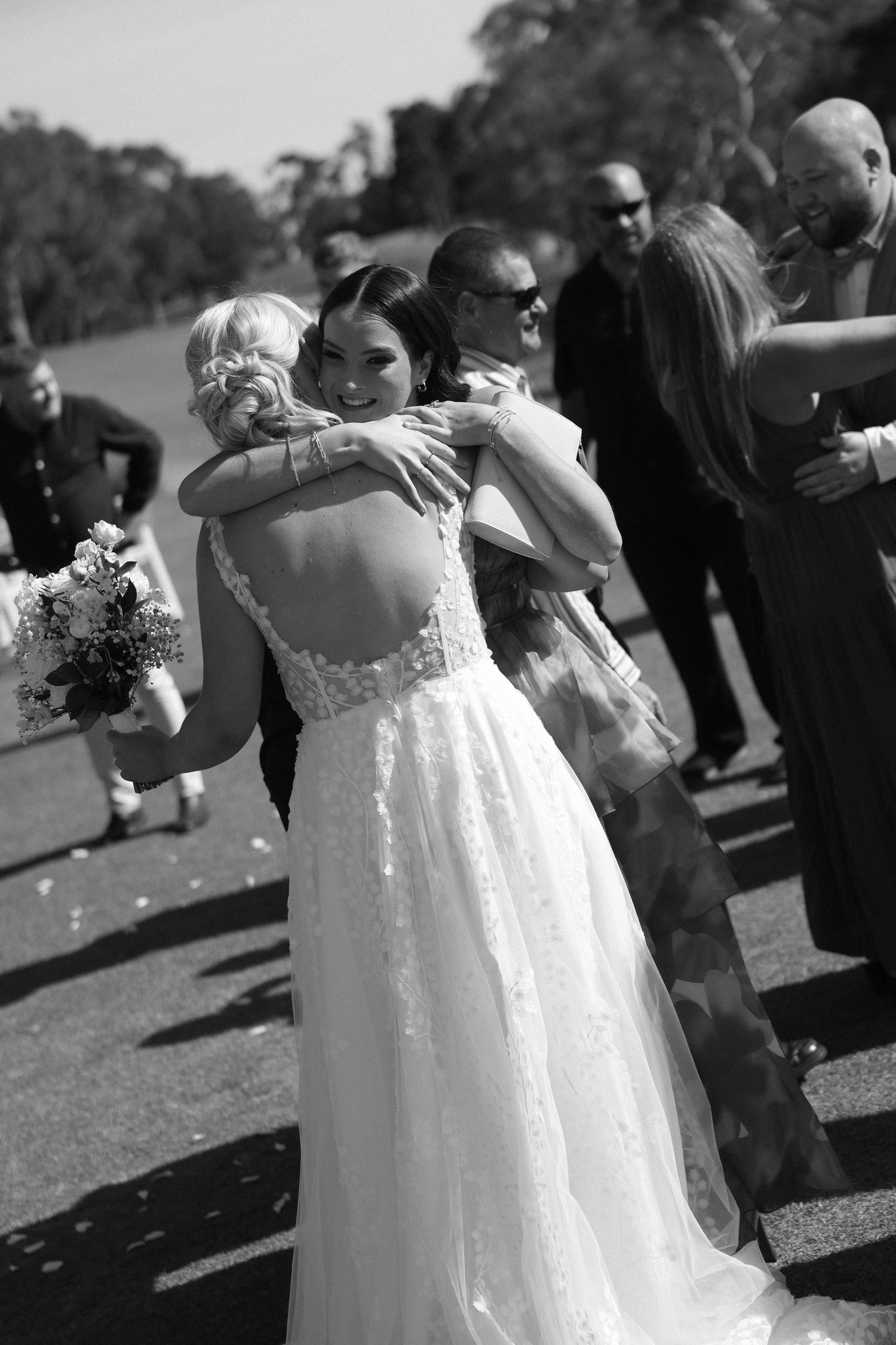 A heartfelt embrace captured during outdoor wedding celebrations.
