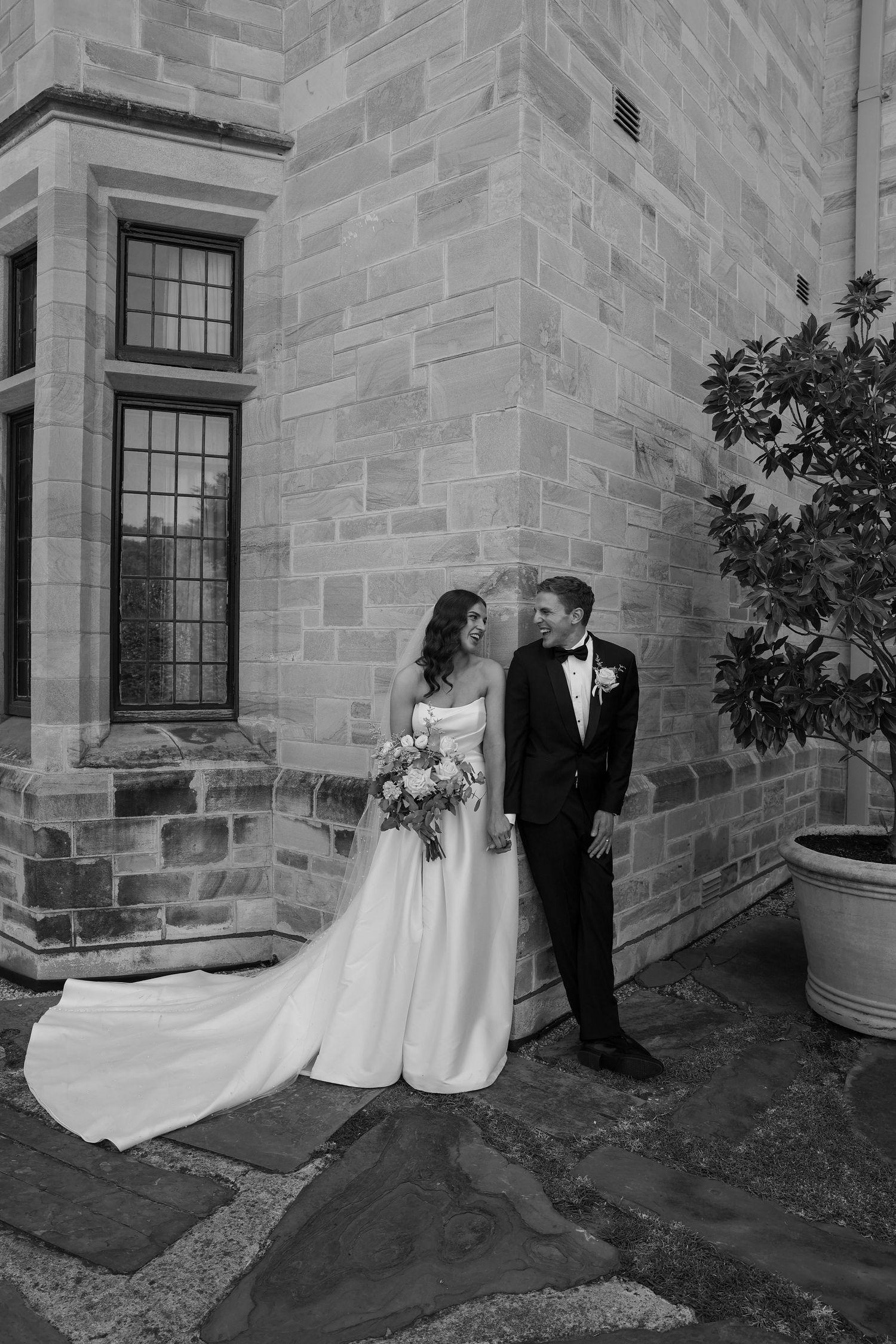 Black and white wedding photographs showing romantic moments against a stone building exterior.