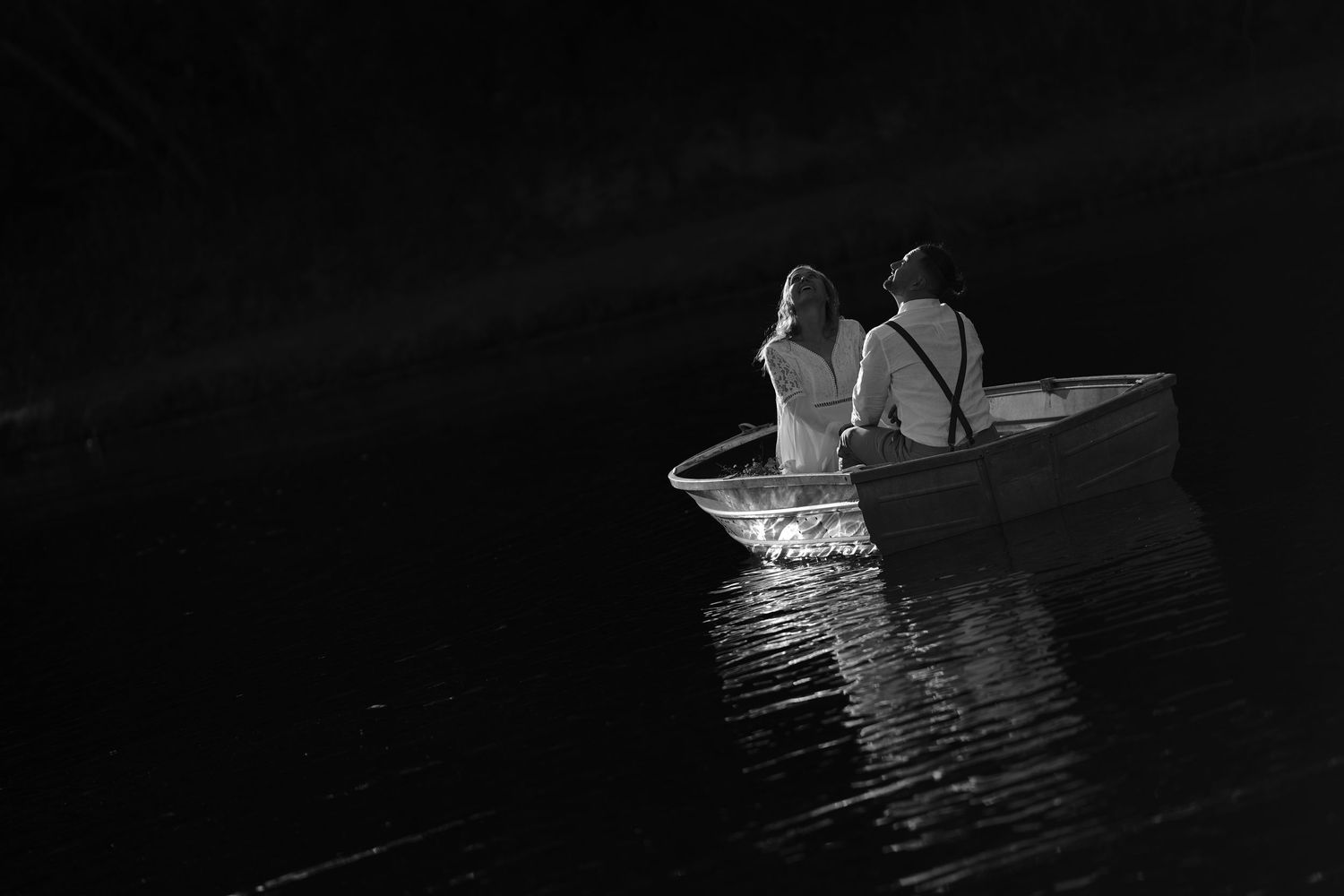A series of dark silhouettes of a small boat moving across calm water at night.