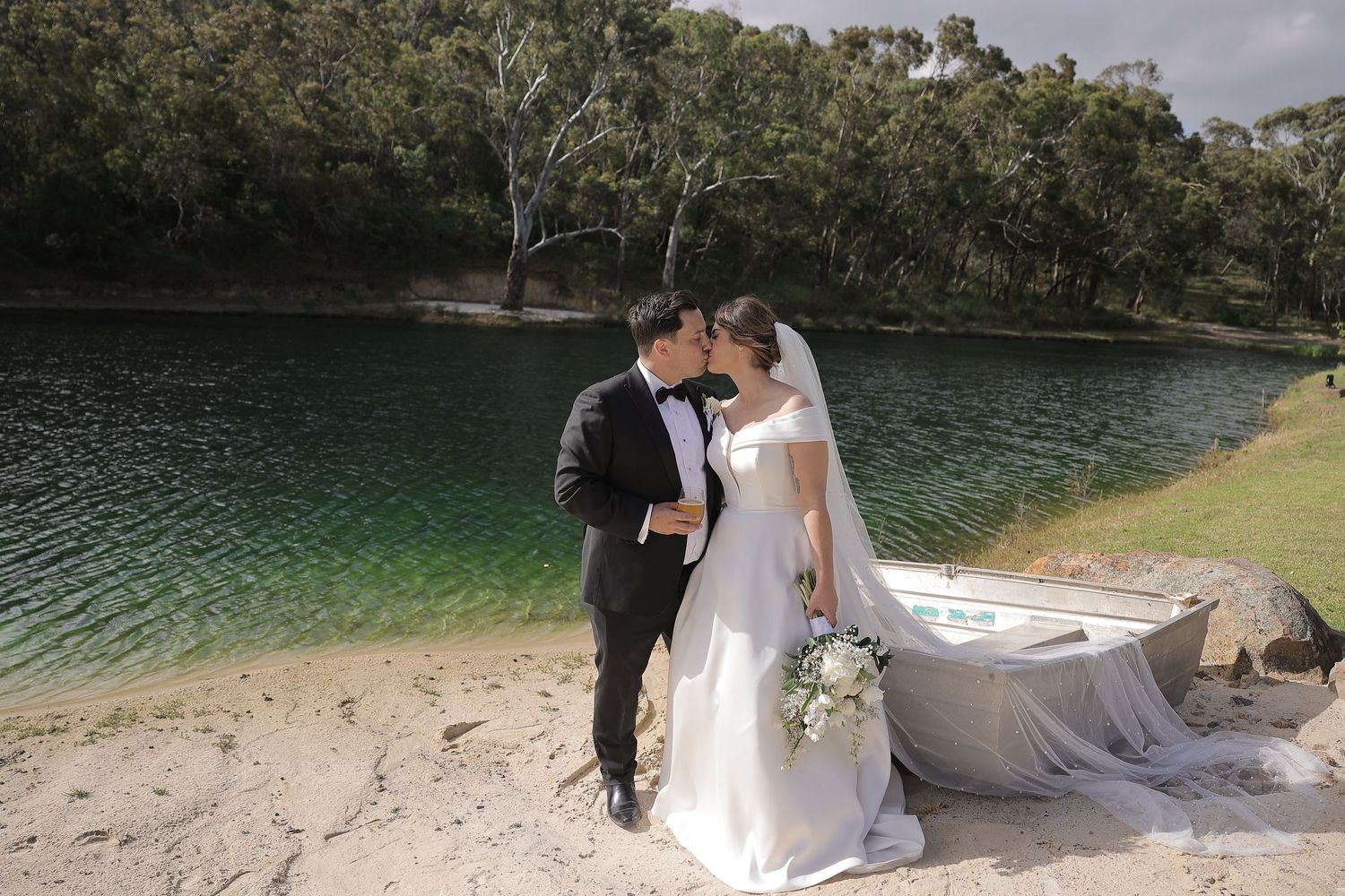 A romantic wedding couple embraces beside emerald green waters and eucalyptus trees. wedding photo tiny house by the Pirie