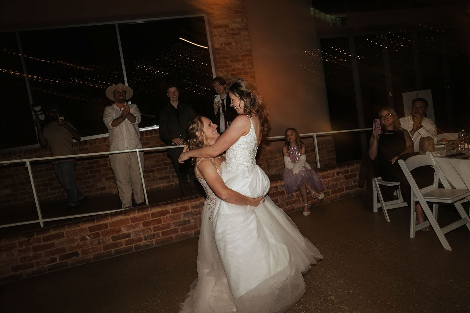 Wedding celebration in a rustic venue with exposed brick walls and ambient lighting.