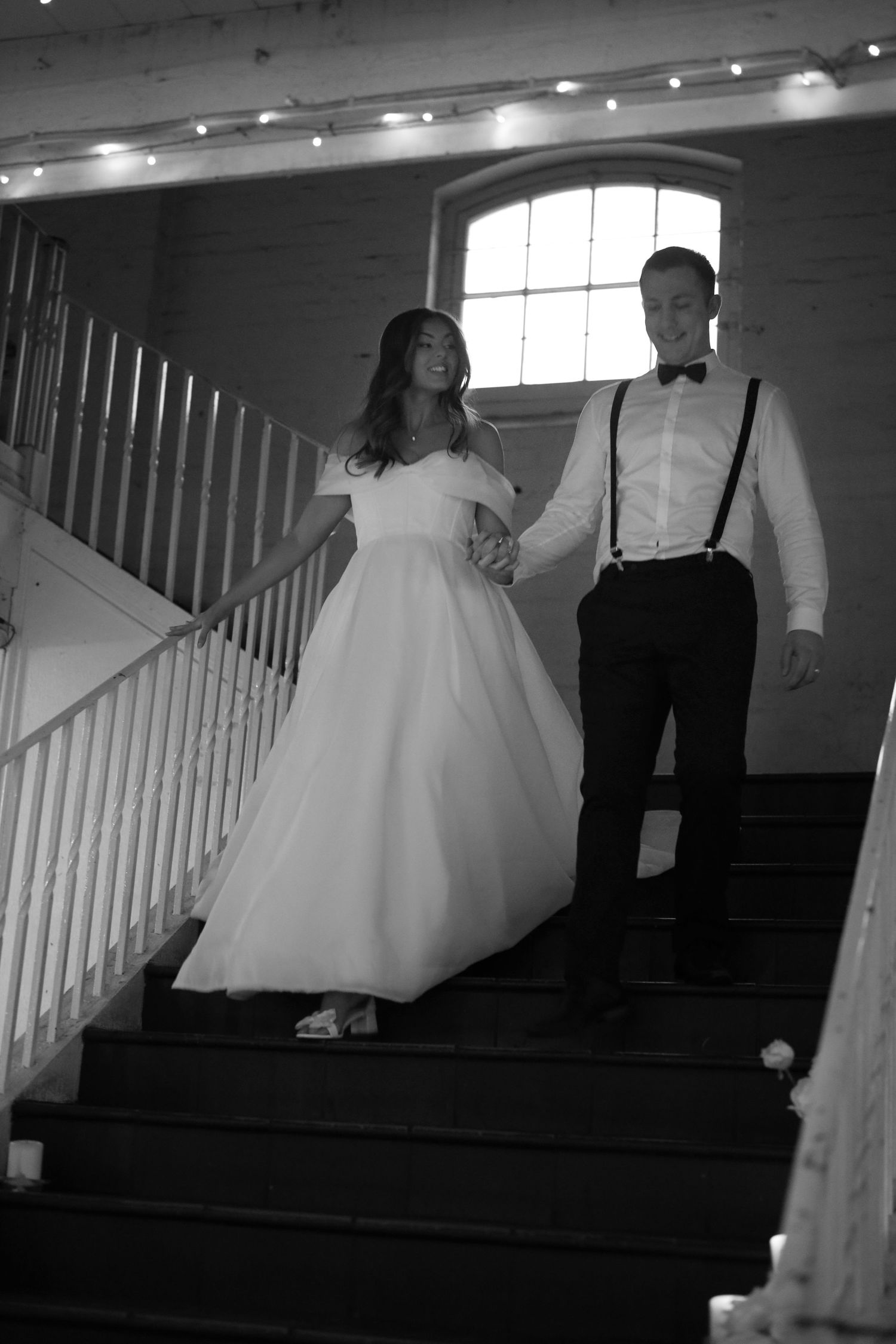 A black and white photo sequence shows a bride in a flowing white gown ascending stairs during a wedding ceremony.