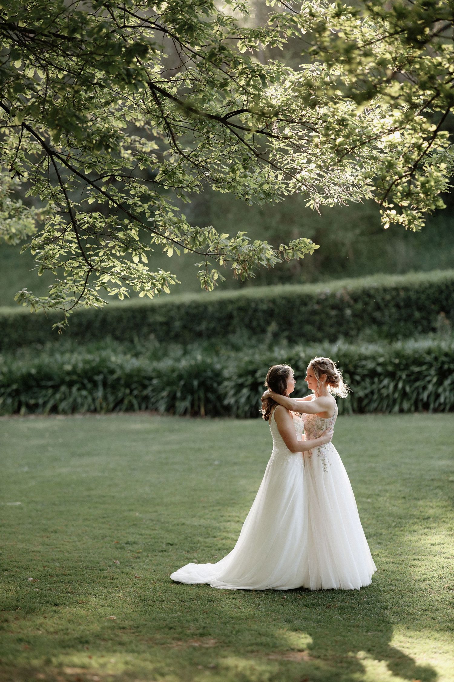 A romantic wedding photoshoot sequence showing a couple dancing together on a sunlit lawn with trees.