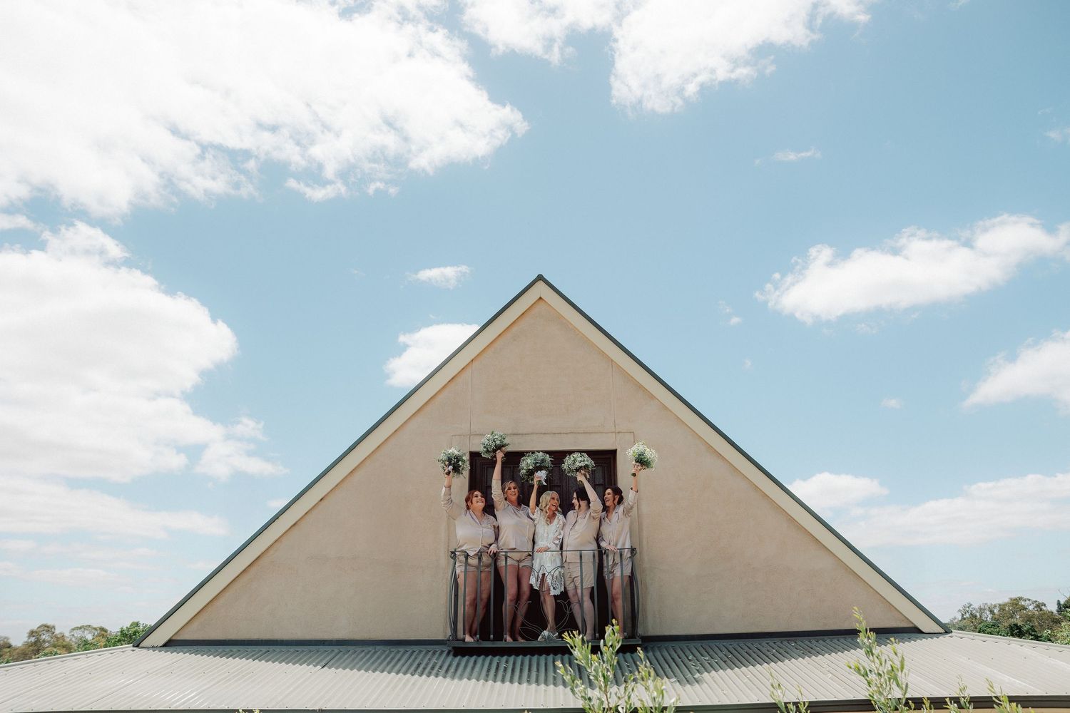 A series of five photos showing people posing in front of a white triangular building on a sunny day.