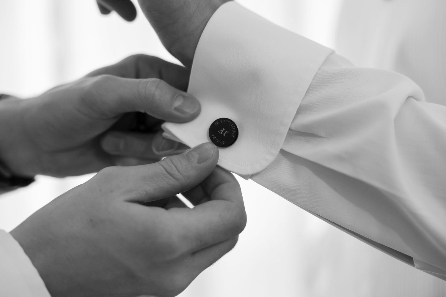 Close-up view of hands exchanging a small business card or document against a light background.