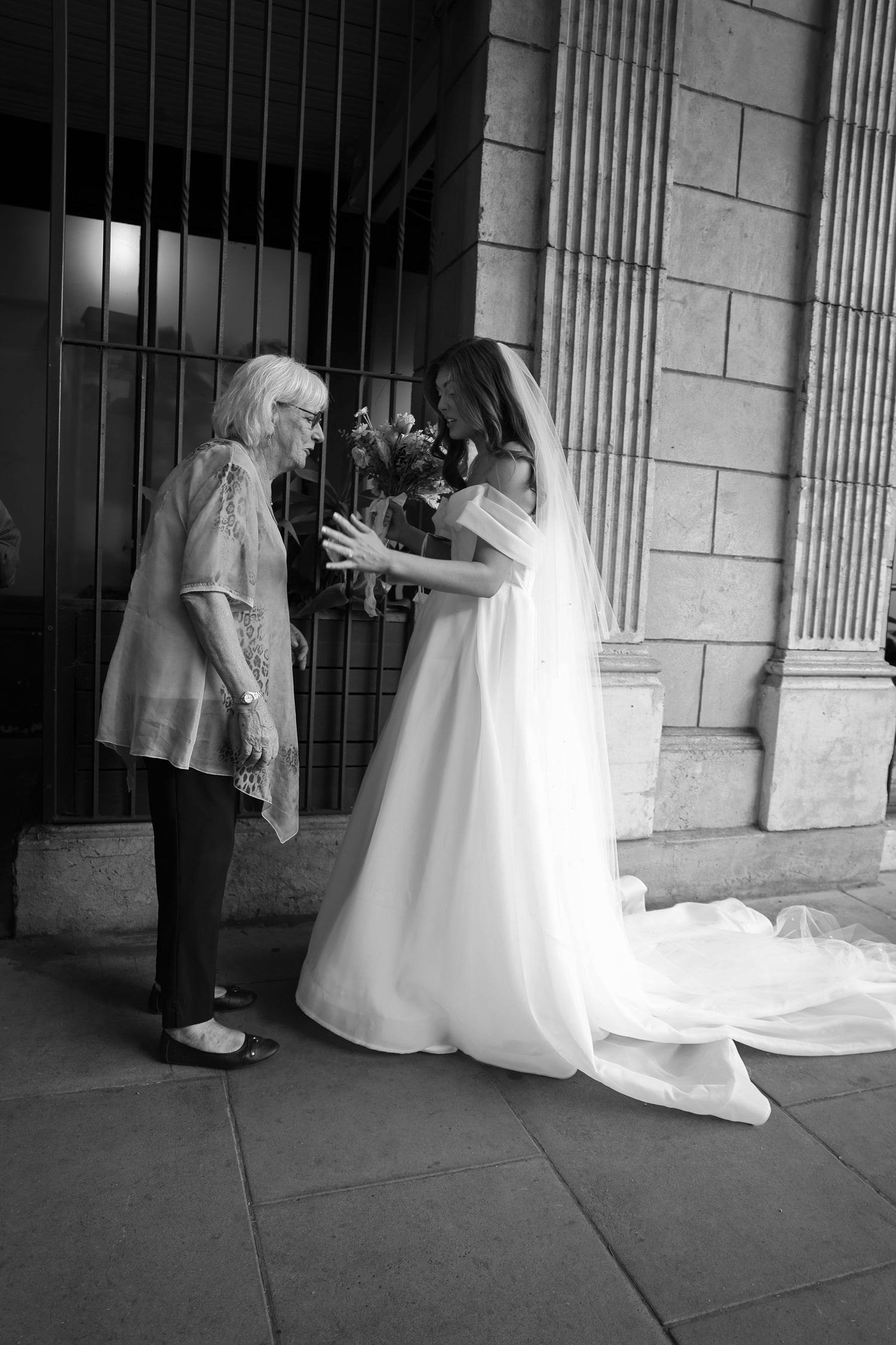 A series of black and white photos showing figures in white dresses moving through a columned architectural space.