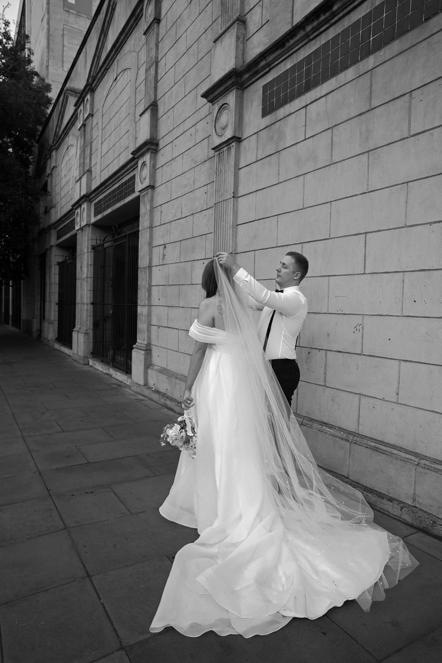 Black and white wedding photography sequence against a stone wall exterior.