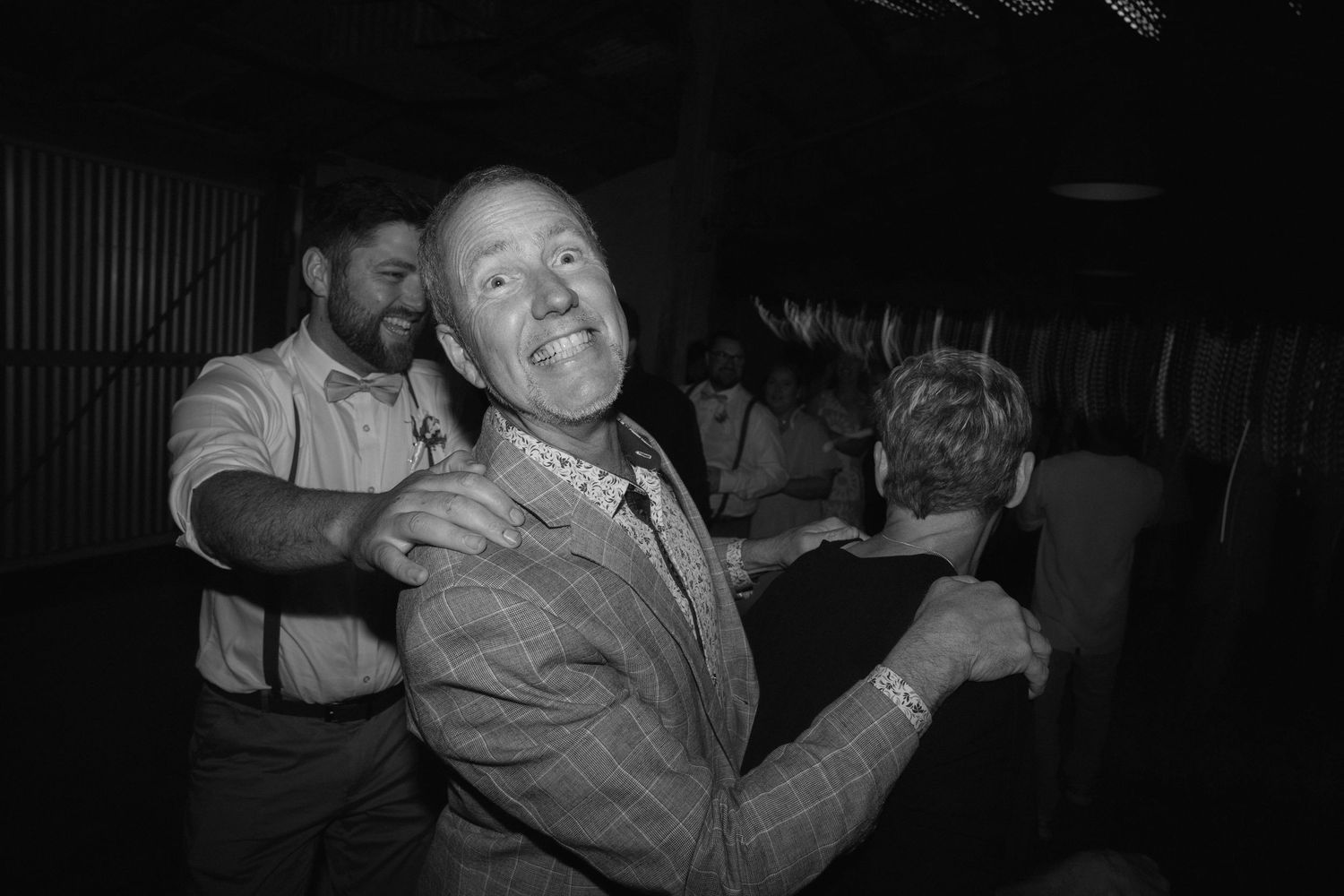 A series of black and white photographs showing people dancing and embracing at what appears to be a social gathering.
