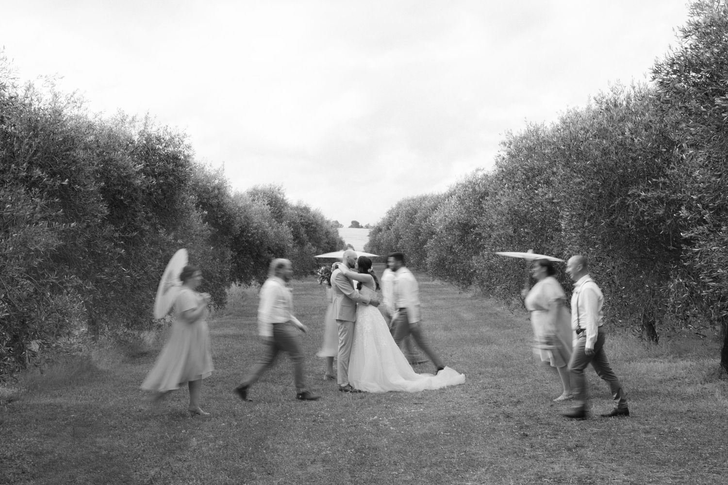 A sequence of vintage photographs showing people dancing and moving in an outdoor garden or orchard setting.