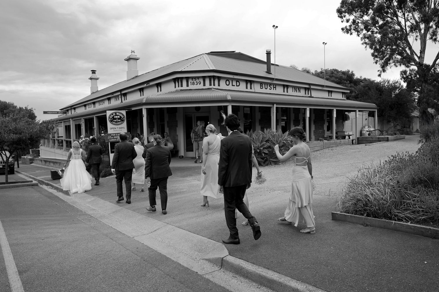 A series of black and white photos showing people walking together outdoors in formal attire.