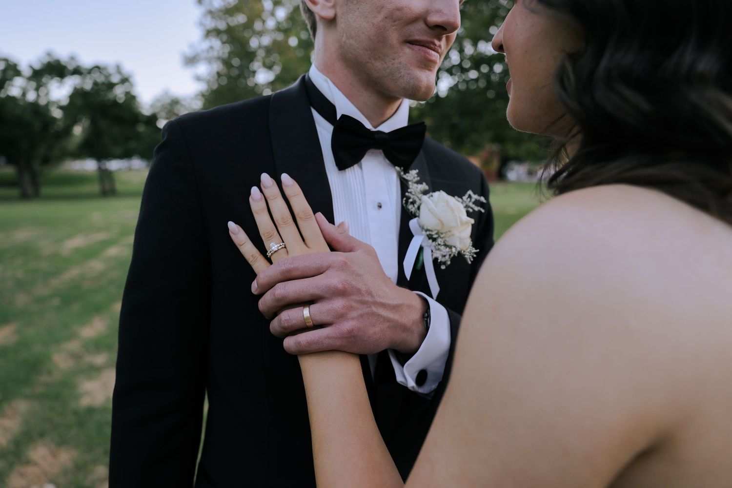 A couple shares an intimate moment during their wedding celebration outdoors.