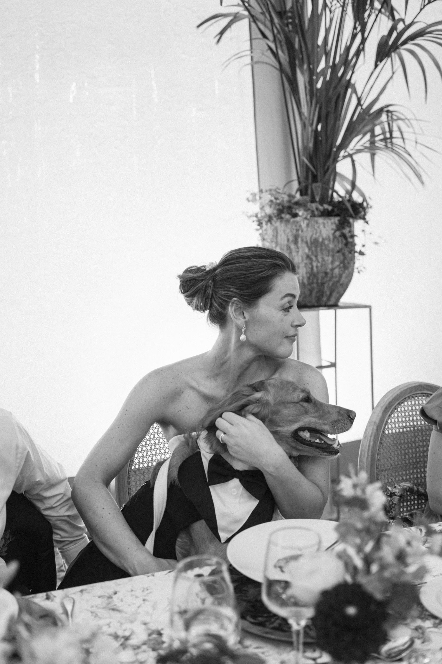 A sequence of black and white photos showing playful dining moments at an elegant table setting.