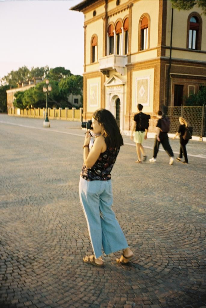 Person walking on cobblestone courtyard in front of ornate European-style building.