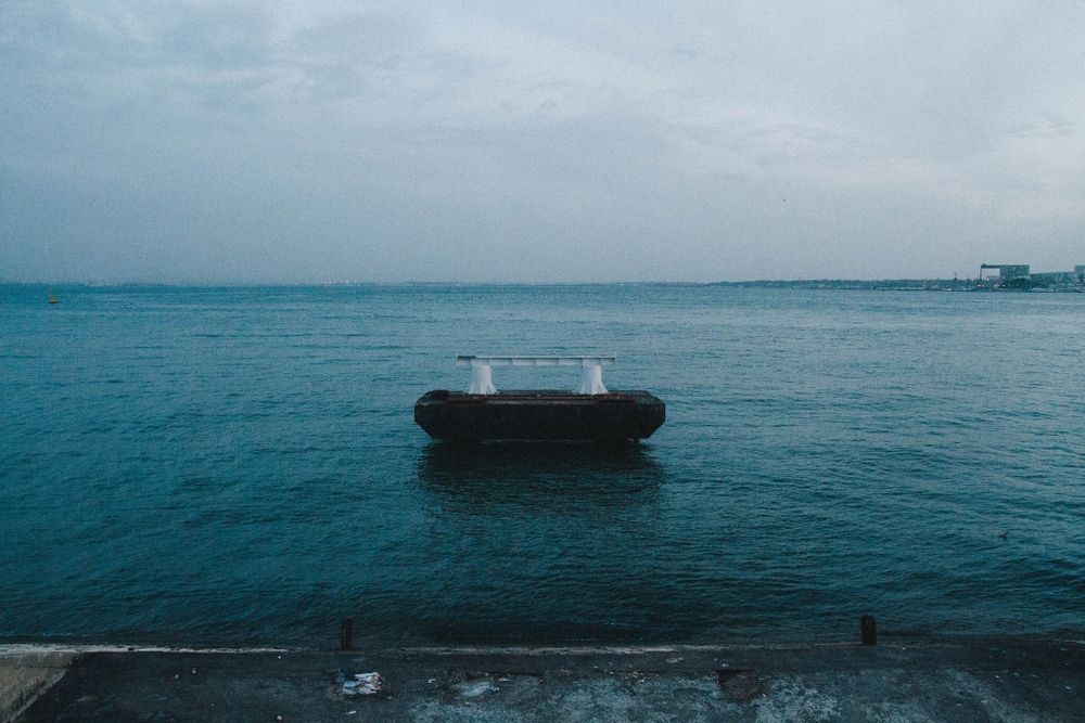Serene ocean view with boats visible on calm water horizon.