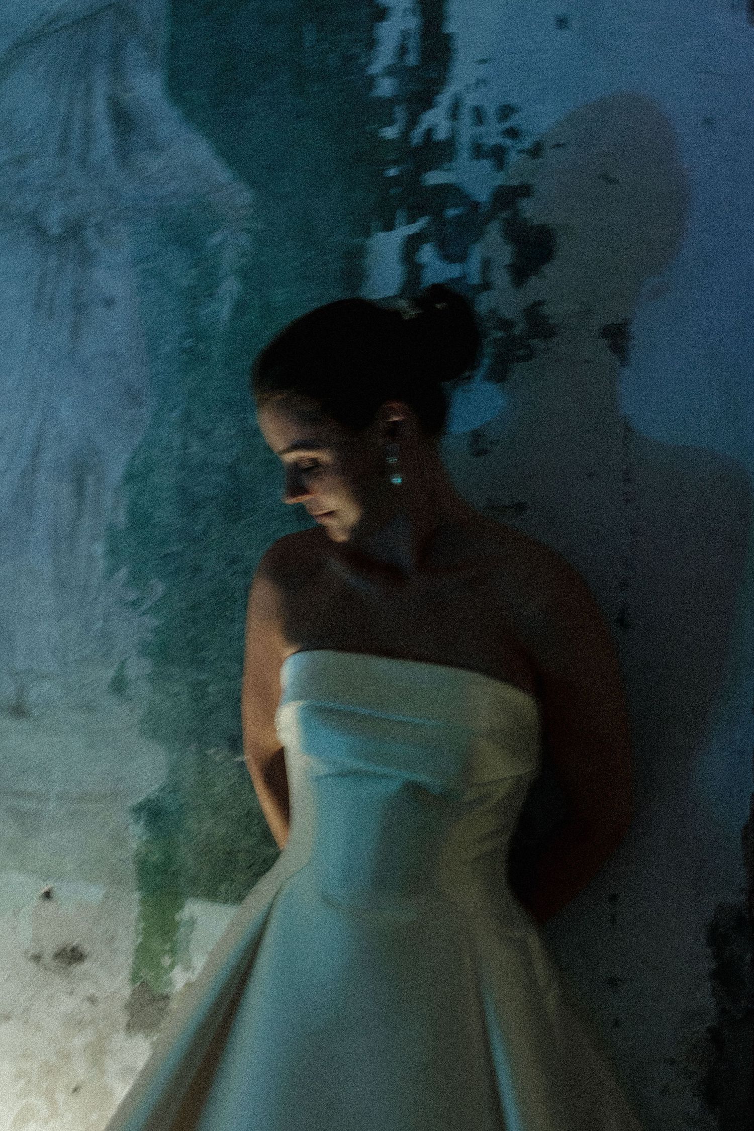 Artistic sequence showing figure in white dress against textured wall.