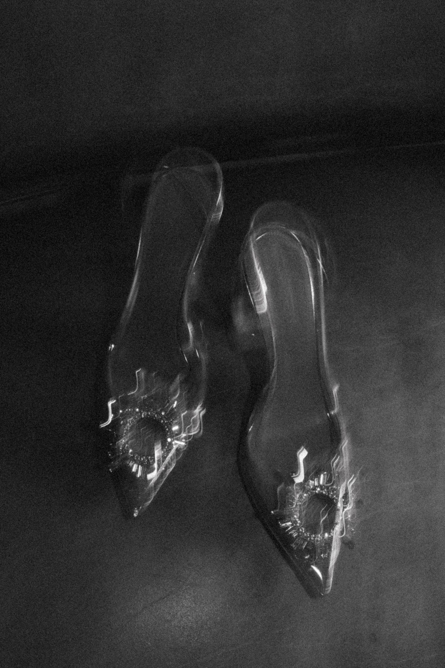 Black and white artistic photograph of empty wine glasses on a dark background.