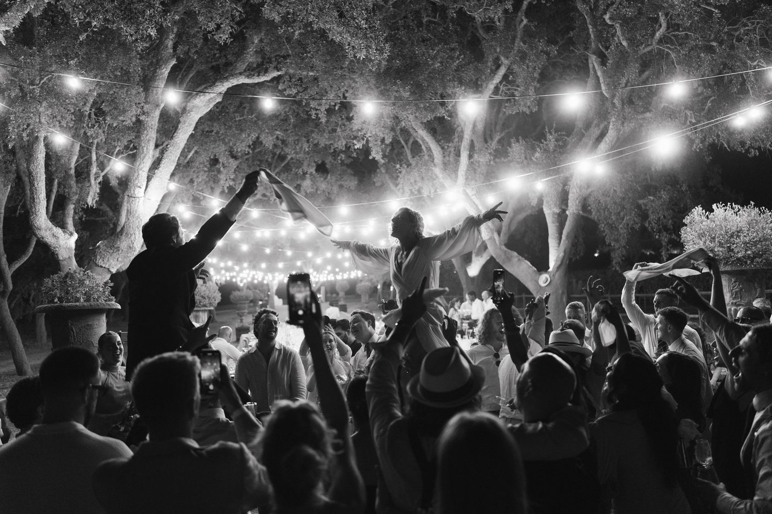 A concert crowd silhouetted against bright stage lights creates an energetic nighttime atmosphere.