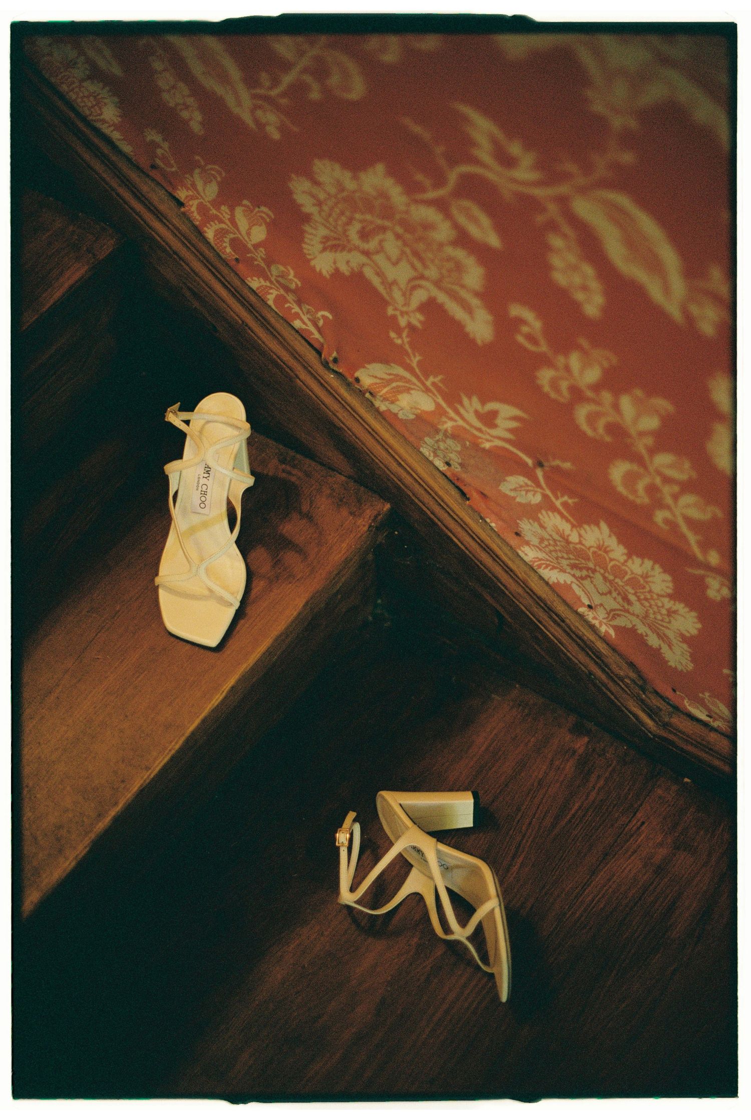 Vintage paper origami figures arranged on a dark wooden surface with red damask wallpaper.