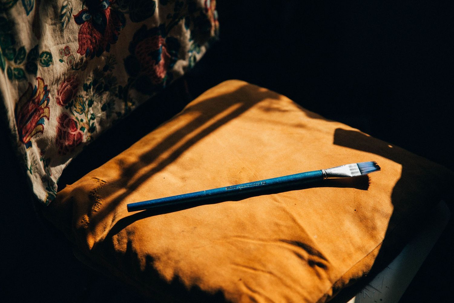 Close-up view of orange leather material with dark shadows and folds.