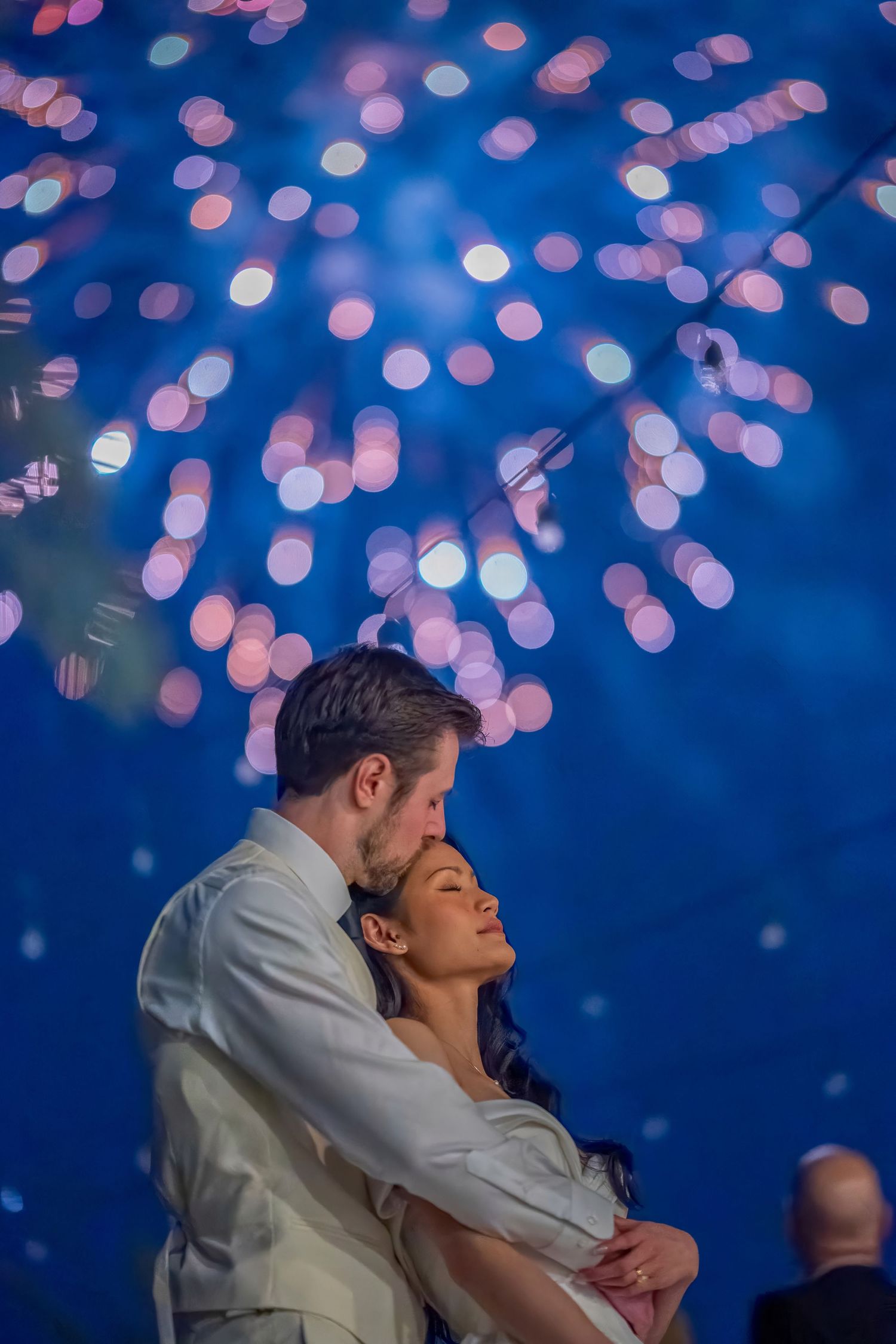 Romantic dance under sparkling fireworks display creating magical wedding moment.