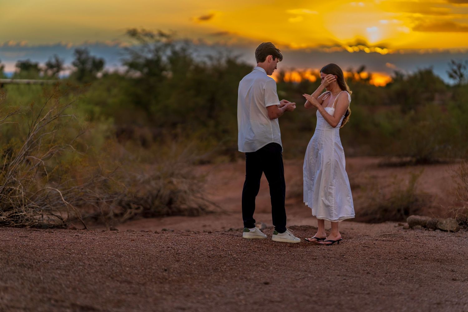 A couple shares a tender moment in the desert during a golden sunset photo shoot.