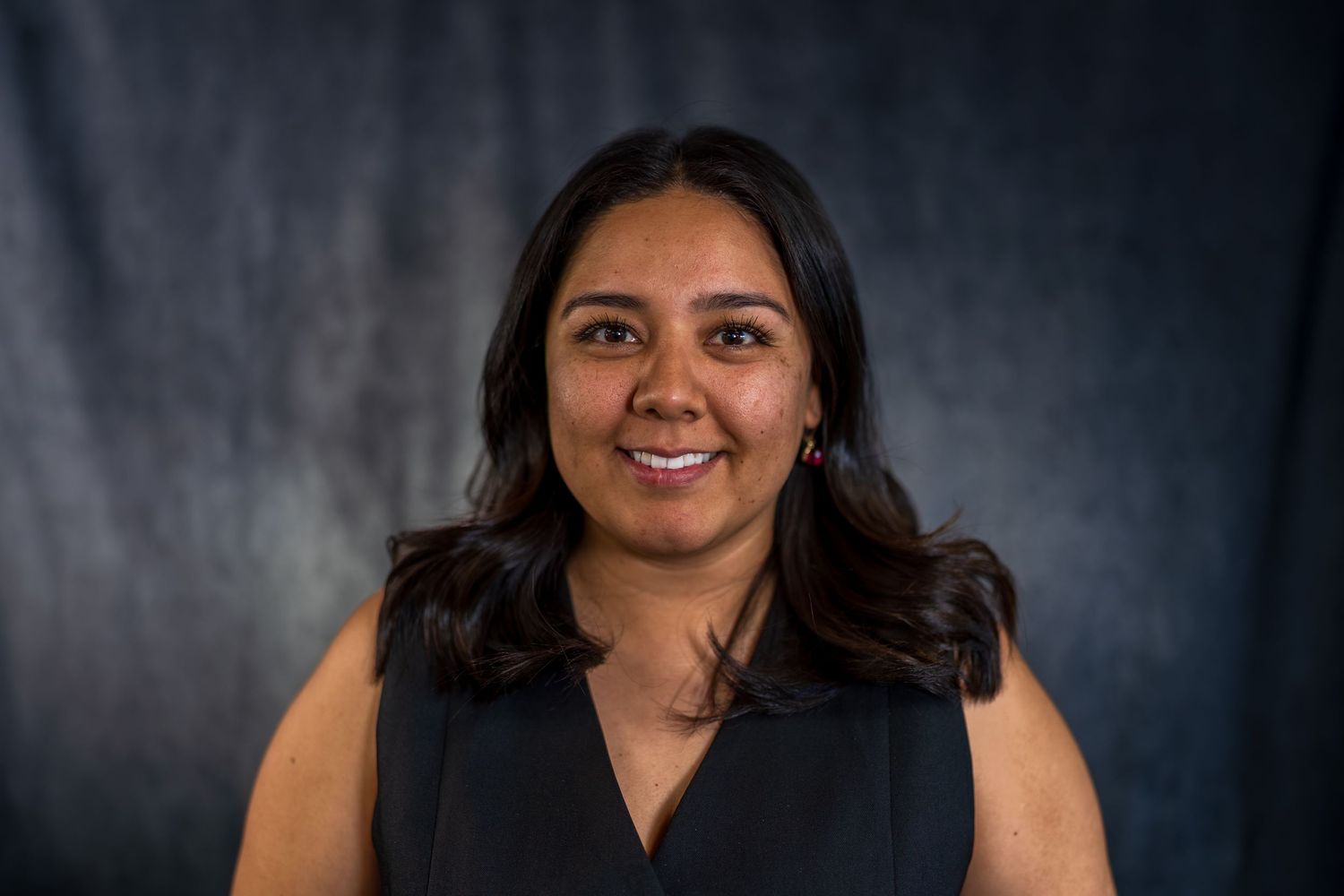 Studio portrait series showing genuine smile in dark professional attire.